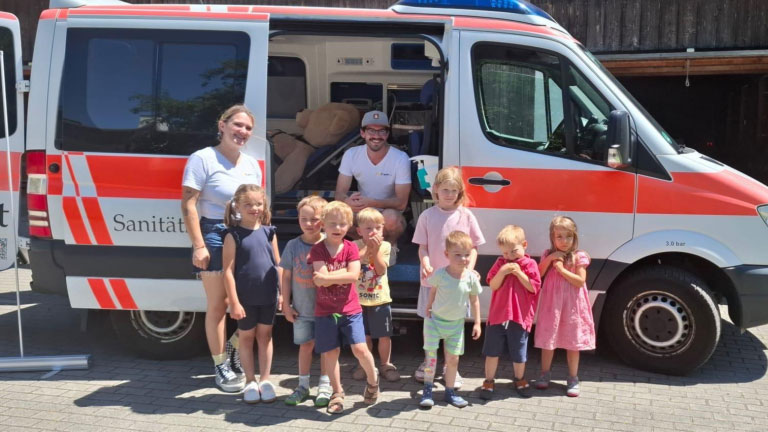 PädCare und Kinder vor einem Krankenwagen